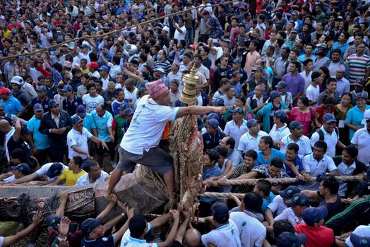 NEPAL, Patan: Hindus and Buddhists gather around the chariot of Rato Machhindranath as it is pulled along a river in Patan, Lalitpur, Nepal, on September 23, 2015. 