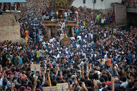 NEPAL, Patan: Hindus and Buddhists gather around the chariot of Rato Machhindranath as it is pulled along a river in Patan, Lalitpur, Nepal, on September 23, 2015. 