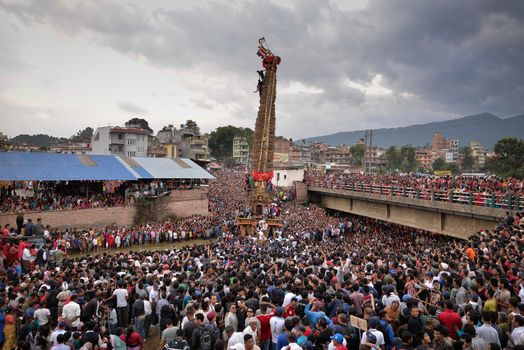 NEPAL, Patan: Hindus and Buddhists gather around the chariot of Rato Machhindranath as it is pulled along a river in Patan, Lalitpur, Nepal, on September 23, 2015. 