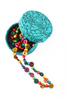 Colorful handmade wooden round beads necklace partly taken out of jewelry box isolated on white