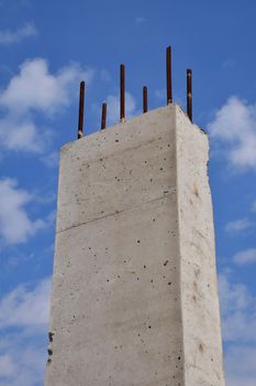 Reinforced concrete pillar against cloudy blue sky