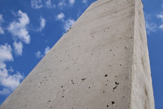 Concrete pillars against cloudy blue sky