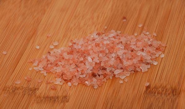 Himalayan pink salt batch over wooden bamboo background, angle view