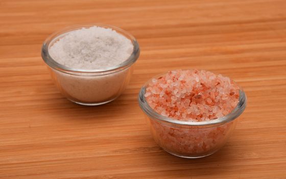 Choose your salt - Himalayan or rock salt (angle view) on wooden bamboo background
