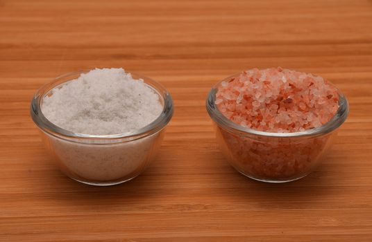 Choose your salt - Himalayan or rock salt (side view) on wooden bamboo background