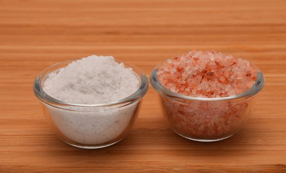 Choose your salt - Himalayan or rock salt (side view) on wooden bamboo background