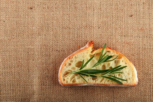 Jute canvas with rosemary leaves on slice of white wheat bread, add your text
