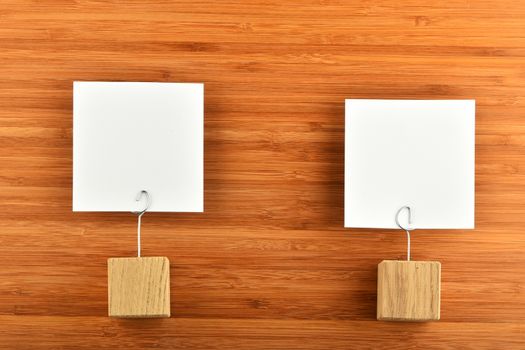 Couple - Two white paper notes with wooden holders on bamboo wooden background for presentation
