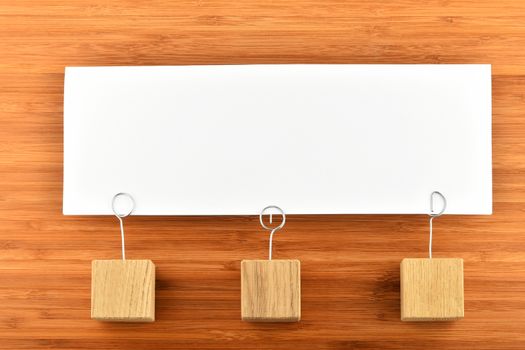 Together, one big white paper note with three wooden holders on wooden bamboo background for presentation
