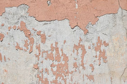 Vintage flakes of old pink paint over grey concrete wall