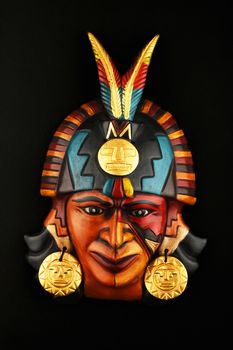 Indian Mayan Aztec ceramic mask with feather isolated on black paper background