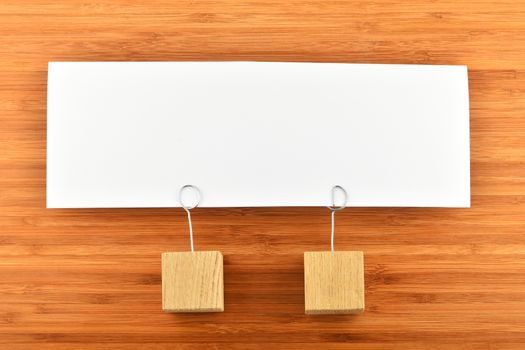 Together, one big white paper note with two wooden holders on wooden bamboo background for presentation