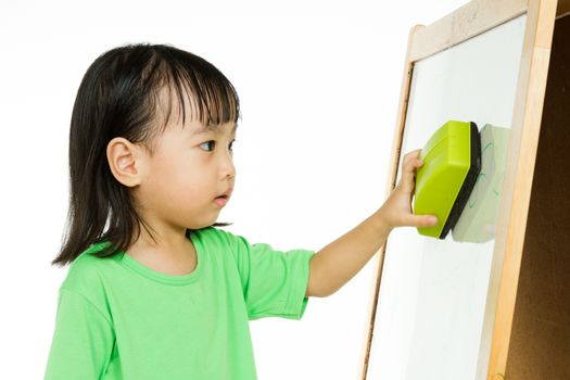 Happy cute Asian Chinese toddler girl drawing or writting with marker pen on a blank whiteboard at home, preschool, daycare or kindergarten in plain white isolated background.
