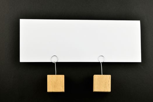 Together, One big white paper note with two wooden holders isolated on black paper background for presentation