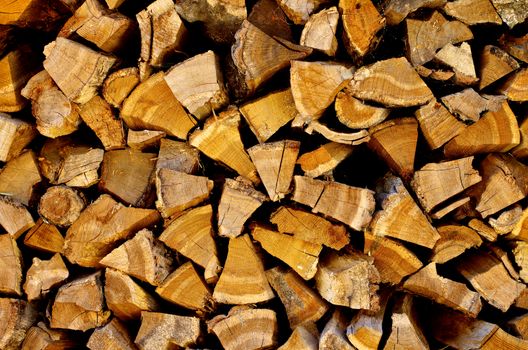 Background of Stacked Rough Firewood Pinned Segments closeup Outdoors