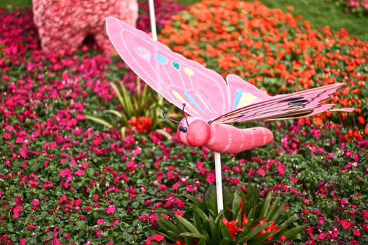 Butterfly statue with blur flowers background