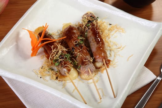 Japanese cuisine chicken skewers on white plate