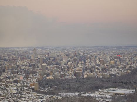 Sapporo city in evening, view from the summit of Mount Okura in winter.