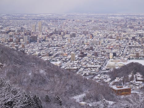 Sapporo city in evening, view from the summit of Mount Okura in winter.