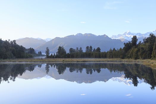 Reflection of Lake Matheson with Mount Cook and Mount Tasman as background, West Coast region, South Island, New Zealand.