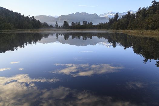 Reflection of Lake Matheson with Mount Cook and Mount Tasman as background, West Coast region, South Island, New Zealand.