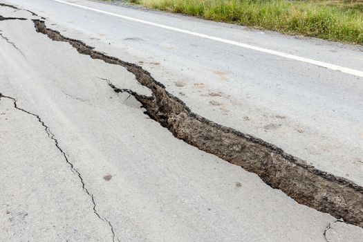 Cracked and broken asphalt road from earthquake.
