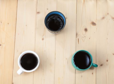 three cup of coffee on wood table