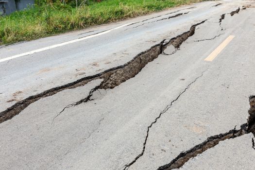 Cracked and broken asphalt road from earthquake.