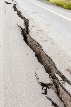 Cracked and broken asphalt road from earthquake.