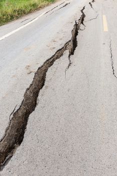 Cracked and broken asphalt road from earthquake.