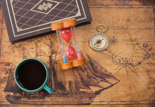 hot coffee cup and compass on old map