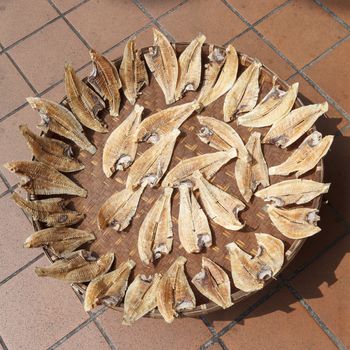 Sun dried fish on bamboo basket.