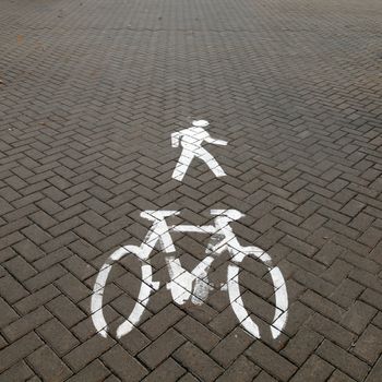 White painted sign for bikes and pedestrian.