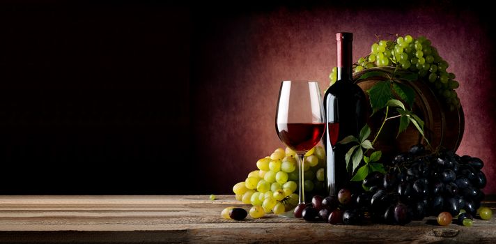 Vine of grape with wine on wooden table