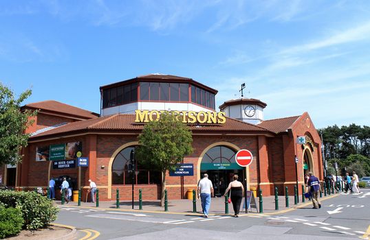 SCARBOROUGH, NORTH YORKSHIRE, ENGLAND - 15th of July 2013: People walking into the Morrisons supermarket to do their weekly shopping. This is one of the most popular supermarkets in England.