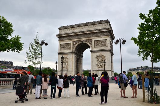 Paris, France - May 14, 2015: Tourist visit Arc de Triomphe de l'Etoile in Paris. Arc de Triomphe was built in 1806-1836 by architect Jean Shalgrenom by order of Napoleon to commemorate victories of his Army.