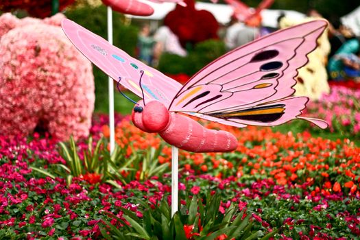 Butterfly statue with blur flowers background