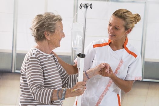 Nurse walking next to a patient with IV drip in hospital