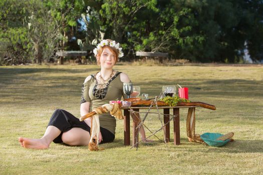 Adult female sitting at pagan altar with wreath