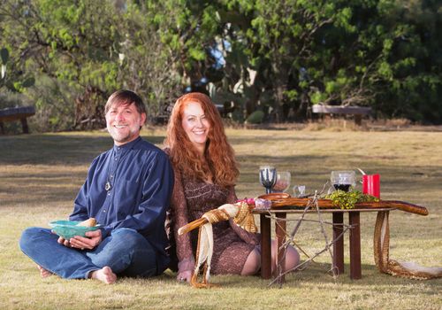 Happy pagan couple at altar with candles and goblets