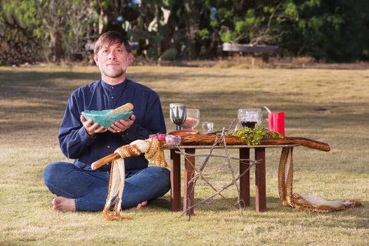 Caucasian bare foot male at pagan altar outdoors