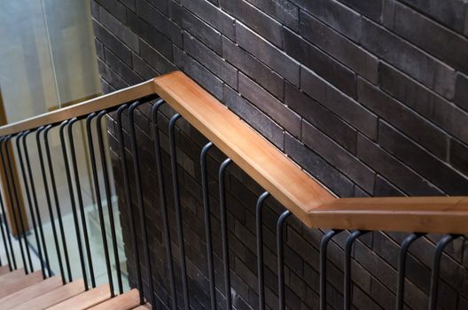 Wooden handrail with brick wall background
