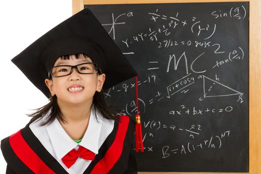 Asian Chinese children in graduation gown againts blackboard or chalkboard with formulas in plain isolated white background.