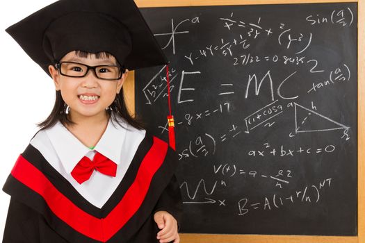 Asian Chinese children in graduation gown againts blackboard or chalkboard with formulas in plain isolated white background.