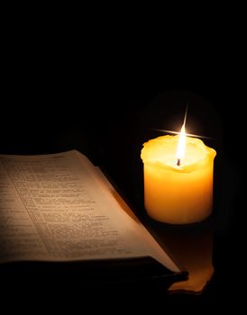 open book and burning candle