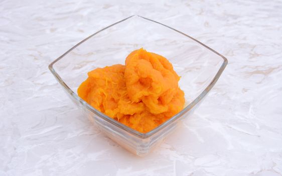 Pumpkin puree in a glass bowl on a kitchen counter