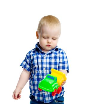 A little boy in checkered shirt plays with a toy car. White background. Studio