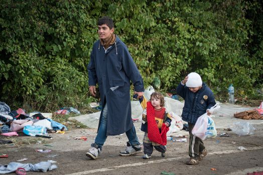 SERBIA, Berkasovo: Children walk through the remains of a makeshift camp as Middle Eastern refugees crossed fields in the Serbian town of Berkasovo, on the border with Croatia on September 24, 2015. 
