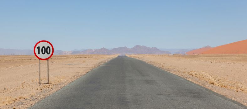 Speed limit sign at a desert road in Namibia, speed limit of 100 kph or mph