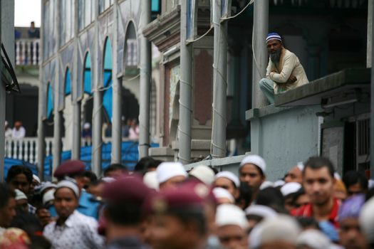 NEPAL, Kathmandu: A man on a balcony watches worshippers celebrate Eid-al-Adha at a Kasmere Jama mosque in Kathmandu, Nepal on September 25, 2015. The festival marks the end of Hajj, which is a holy pilgrimage that many Muslims make every year. People of Islamic faith have felt more comfortable celebrating Eid ul-Adha in Nepal after the country ushered in a new democratic, secularist constitution